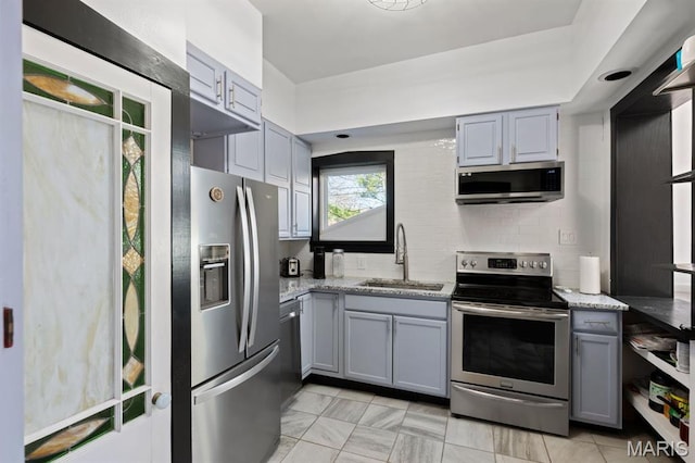 921 Morrison Ave, Saint Louis, MO 63104 - kitchen featuring stainless steel appliances, gray cabinets, a sink, and light stone countertops
