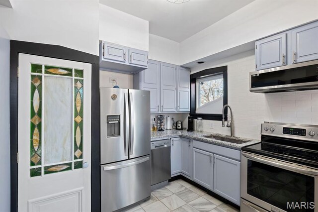 921 Morrison Ave, Saint Louis, MO 63104 - kitchen with appliances with stainless steel finishes, a sink, gray cabinetry, light stone countertops, and decorative backsplash