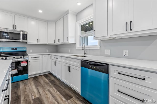 208 Ariel Ct, Desloge, MO 63601 - kitchen with stainless steel appliances, a sink, dark wood-style flooring, white cabinets, and light countertops