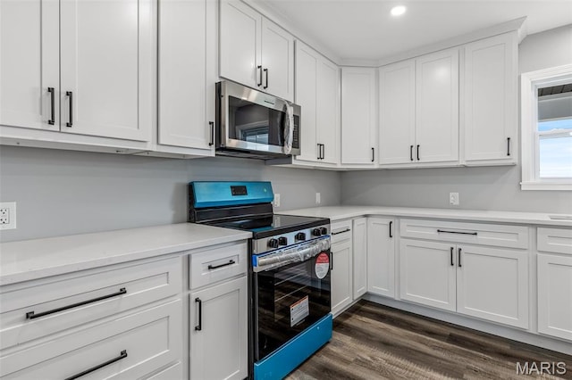 208 Ariel Ct, Desloge, MO 63601 - kitchen featuring appliances with stainless steel finishes, light countertops, white cabinets, dark wood-style flooring, and recessed lighting
