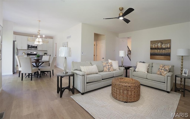 1739 Naughton Way, Swansea, IL 62226 - living area featuring a chandelier, ceiling fan, light wood-style flooring, and baseboards