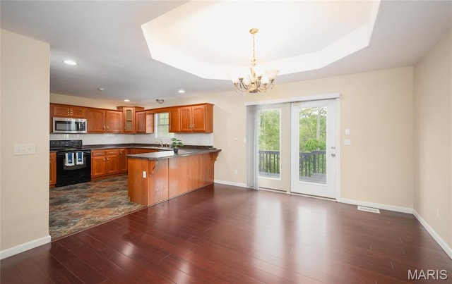 19252 Lambert Ln, Waynesville, MO 65583 - kitchen with stainless steel microwave, electric range, a peninsula, dark countertops, and brown cabinetry
