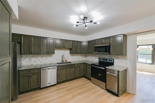 590 Sarah Ln Unit 303, Saint Louis, MO 63141 - kitchen with appliances with stainless steel finishes, a chandelier, a sink, backsplash, and light stone counters