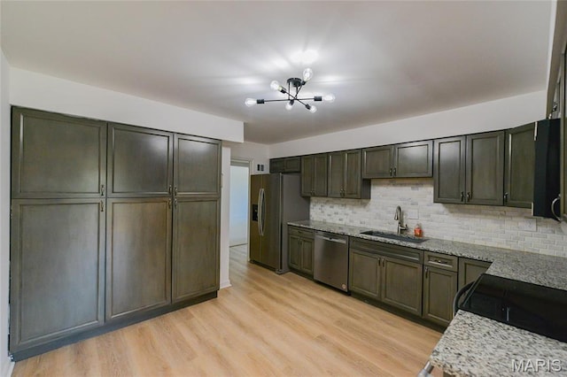 590 Sarah Ln Unit 303, Saint Louis, MO 63141 - kitchen with a sink, appliances with stainless steel finishes, tasteful backsplash, a chandelier, and light stone countertops