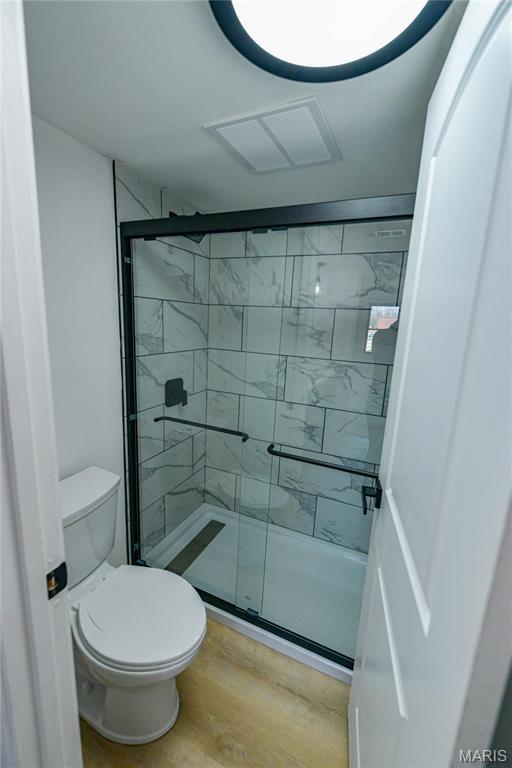 590 Sarah Ln Unit 303, Saint Louis, MO 63141 - bathroom featuring wood finished floors, a shower stall, and toilet