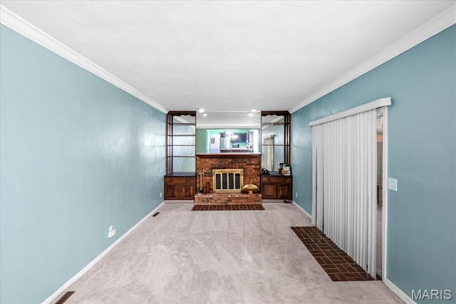 27 Heatherwood Dr, Collinsville, IL 62234 - unfurnished living room featuring crown molding, carpet flooring, a brick fireplace, and baseboards