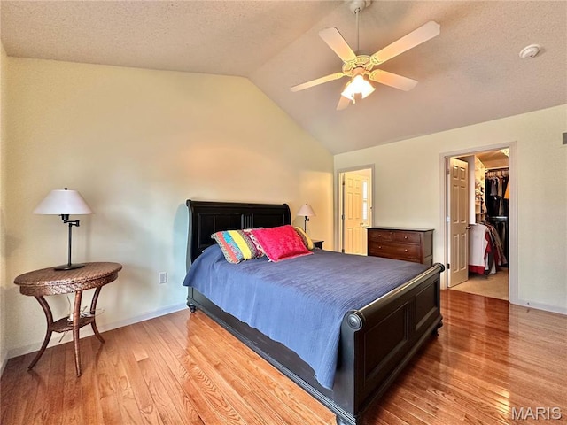 7411 Timberpoint Ct, Fairview Heights, IL 62208 - bedroom with vaulted ceiling, light wood-style flooring, baseboards, a spacious closet, and ceiling fan