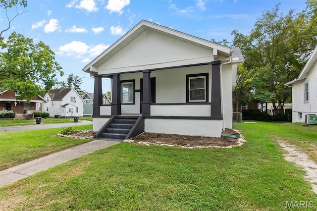 bungalow-style house with covered porch, a front yard, and stucco siding