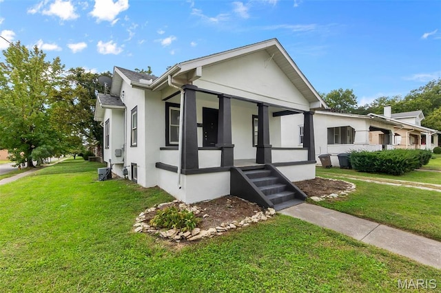 view of front facade featuring stucco siding, covered porch, and a front lawn
