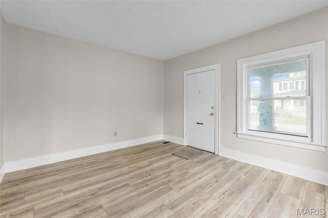 empty room with light wood finished floors and baseboards