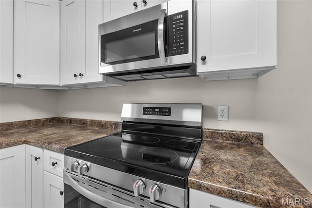 kitchen featuring stainless steel appliances, white cabinets, and dark countertops