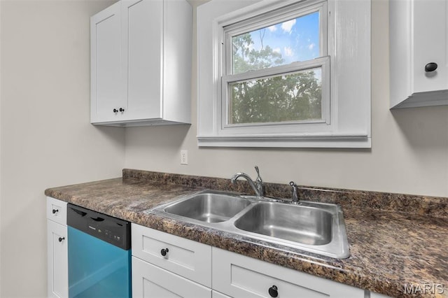 kitchen featuring dishwasher, a sink, dark countertops, and white cabinets
