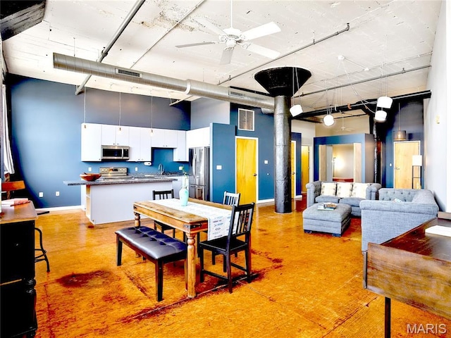 dining space with a towering ceiling, baseboards, and a ceiling fan