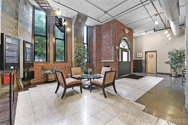 community lobby with a towering ceiling and brick wall
