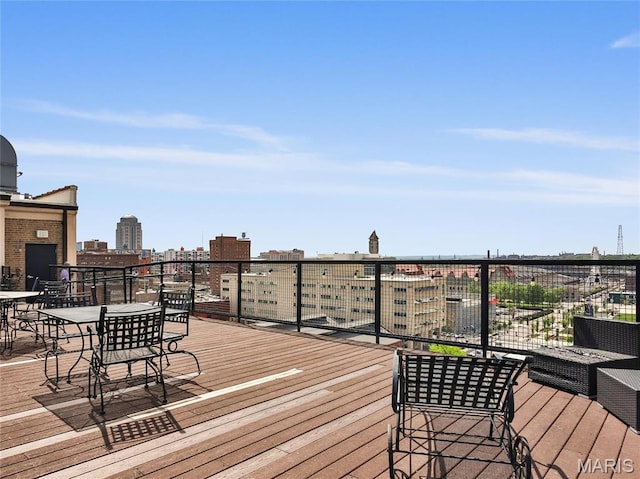 wooden terrace featuring outdoor dining space and a view of city