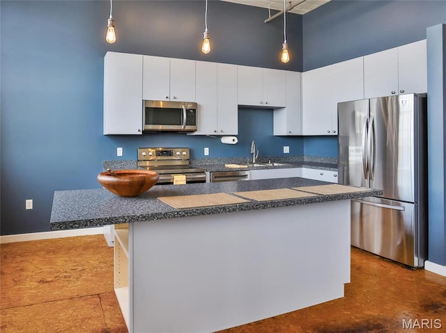 kitchen featuring appliances with stainless steel finishes, dark countertops, a sink, a high ceiling, and white cabinets