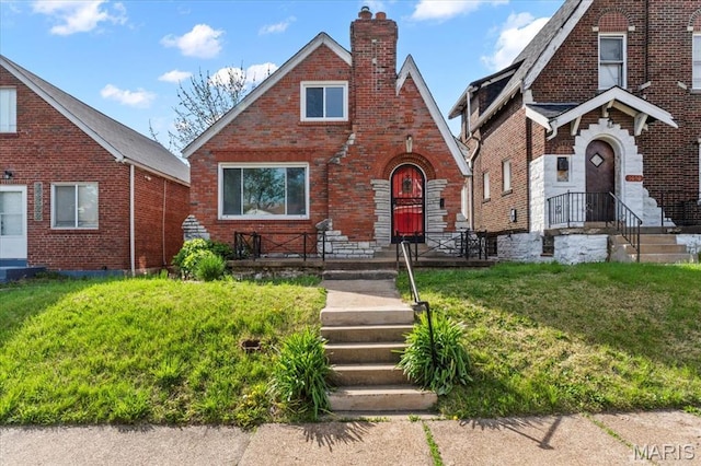 5034 Queens Ave, Saint Louis, MO 63115 - tudor home with a chimney, brick siding, and a front lawn