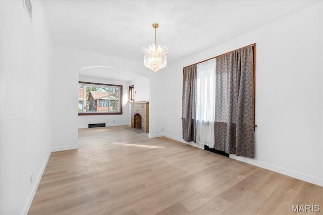 5034 Queens Ave, Saint Louis, MO 63115 - unfurnished dining area with wood finished floors, a chandelier, arched walkways, and baseboards