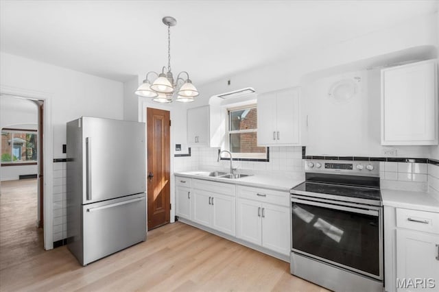 5034 Queens Ave, Saint Louis, MO 63115 - kitchen with stainless steel appliances, a sink, a chandelier, backsplash, and light countertops