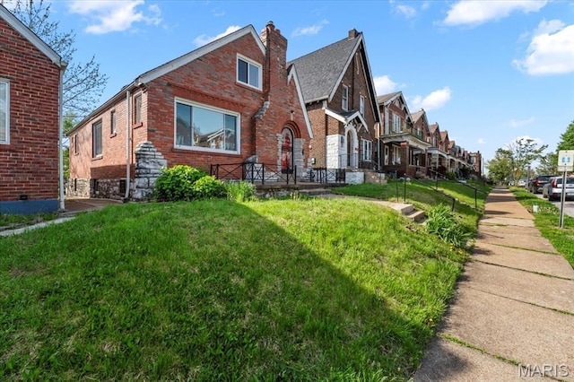 5034 Queens Ave, Saint Louis, MO 63115 - view of front of property with brick siding, a front yard, a chimney, and a residential view
