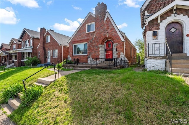 5034 Queens Ave, Saint Louis, MO 63115 - tudor house with brick siding, a chimney, and a front yard