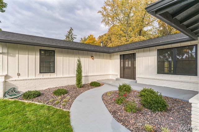11 Forrester Dr, Manchester, MO 63011 - doorway to property with board and batten siding, brick siding, and a shingled roof