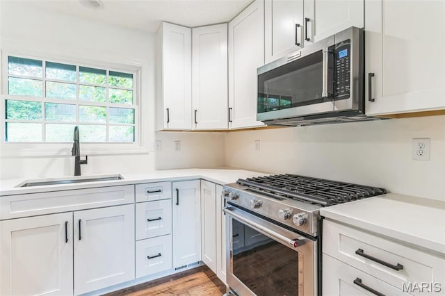11 Forrester Dr, Manchester, MO 63011 - kitchen featuring stainless steel appliances, a sink, light countertops, and white cabinets
