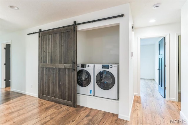 11 Forrester Dr, Manchester, MO 63011 - clothes washing area with separate washer and dryer, a barn door, wood finished floors, baseboards, and recessed lighting