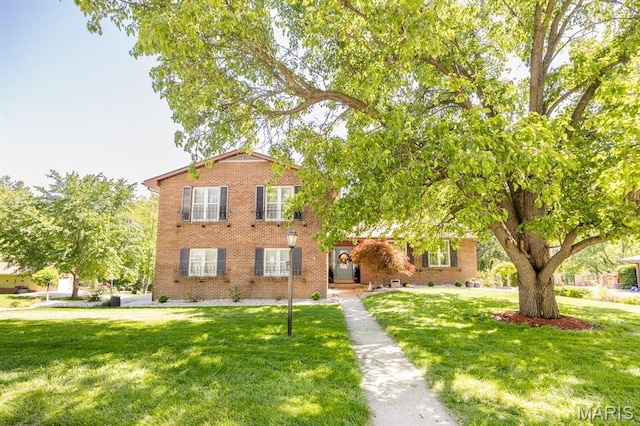 view of front of house with a front lawn and brick siding