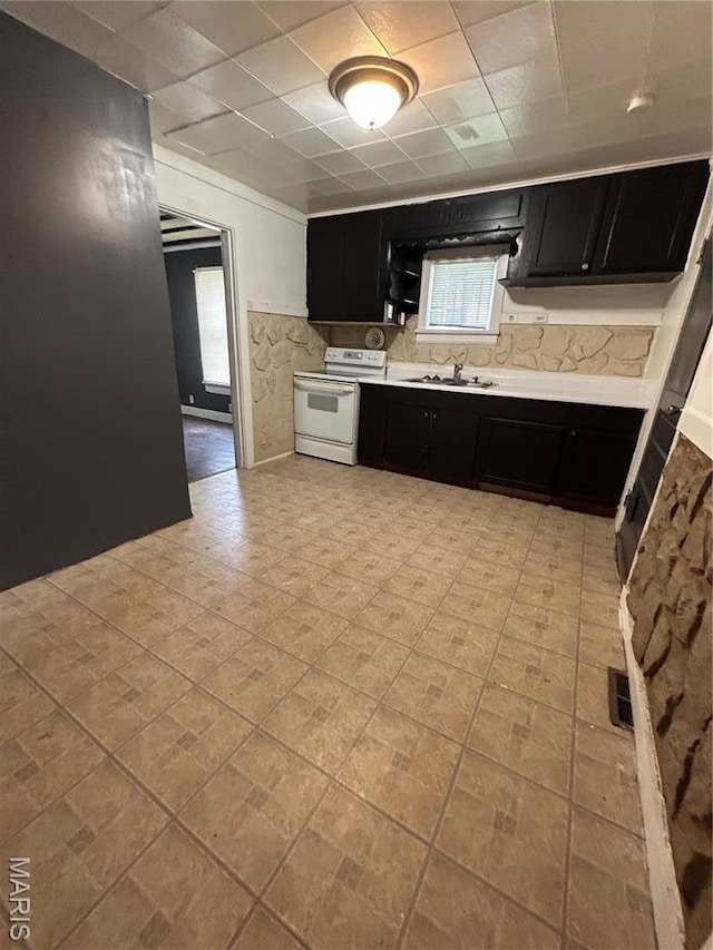 10140 Mayfair Dr, Saint Louis, MO 63136 - kitchen with dark cabinets, white electric stove, light countertops, a sink, and a paneled ceiling