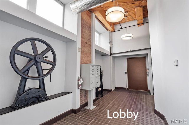 foyer entrance featuring a towering ceiling, baseboards, and a barn door