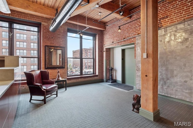 lobby with brick wall, wood ceiling, a high ceiling, and beamed ceiling