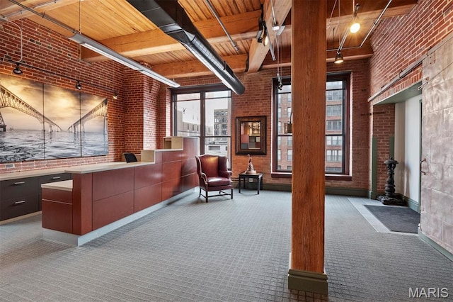 reception area featuring brick wall, wooden ceiling, and beam ceiling