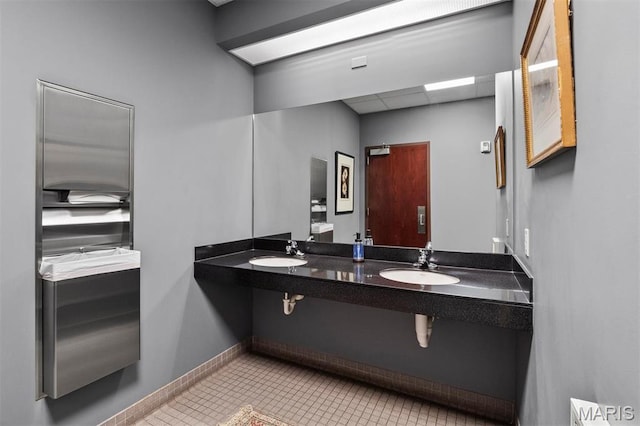 bathroom featuring a sink, tile patterned floors, and baseboards