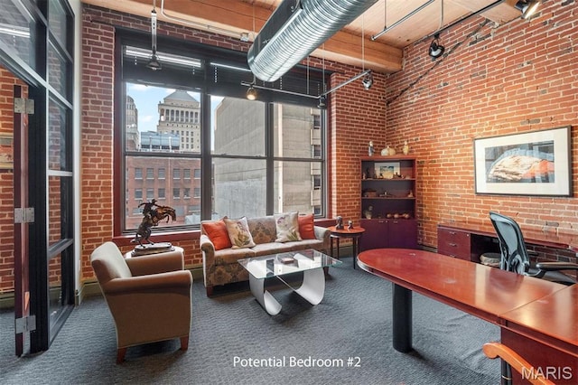 home office with carpet flooring, brick wall, a towering ceiling, and a view of city