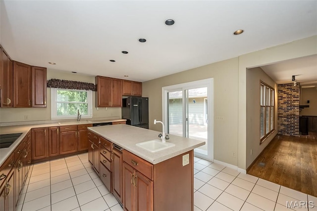 739 Muir View Dr, Ballwin, MO 63011 - kitchen featuring a sink, black appliances, a kitchen island with sink, light countertops, and brown cabinets