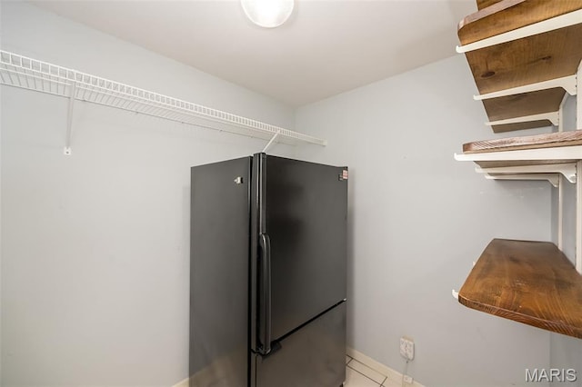 739 Muir View Dr, Ballwin, MO 63011 - kitchen with freestanding refrigerator, tile patterned floors, and baseboards
