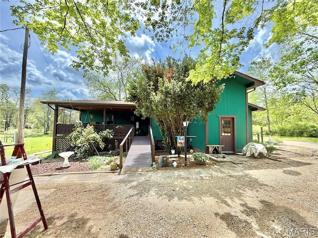 rear view of property featuring covered porch