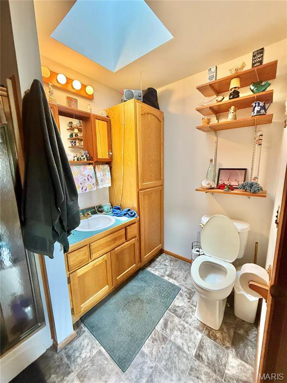 bathroom with vanity, toilet, and baseboards