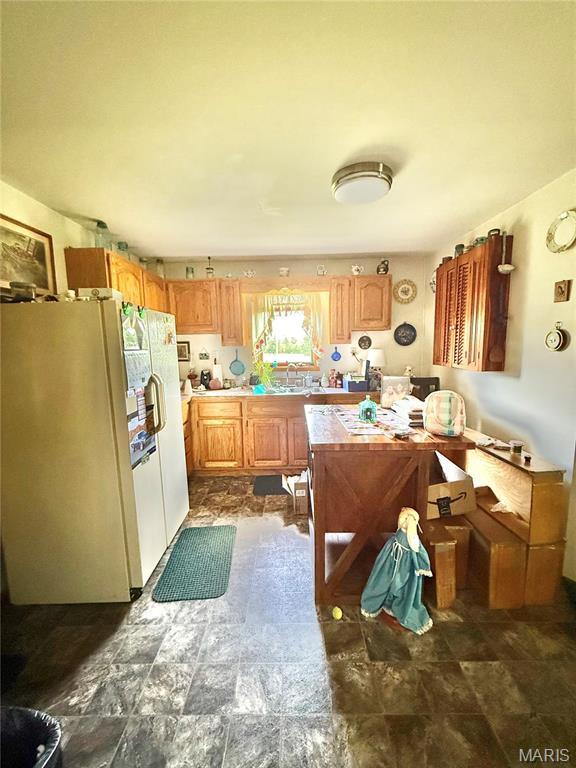 kitchen featuring freestanding refrigerator and light countertops