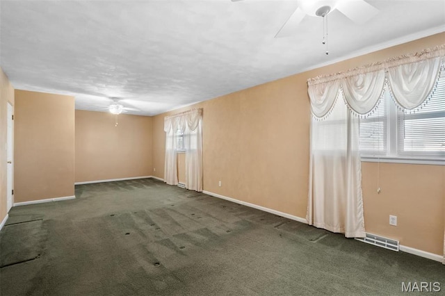 carpeted empty room with a ceiling fan and baseboards