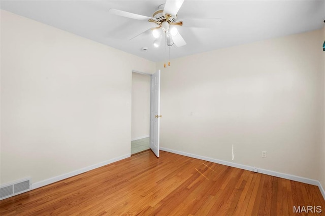 unfurnished room with ceiling fan, light wood-style floors, and baseboards
