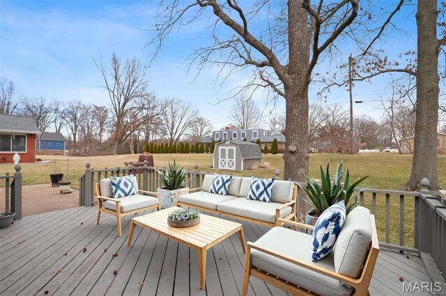 deck with a storage shed, outdoor lounge area, an outbuilding, and a yard
