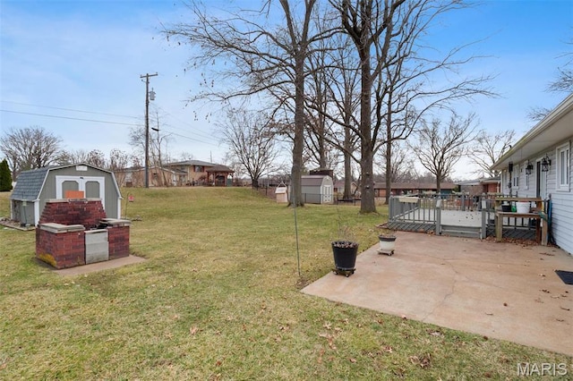 view of grassy yard with a shed, a patio area, a deck, and an outbuilding