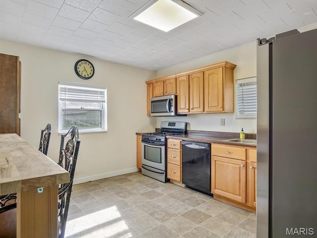 422 Washington St, Red Bud, IL 62278 - kitchen featuring stainless steel appliances, a sink, baseboards, and dark countertops