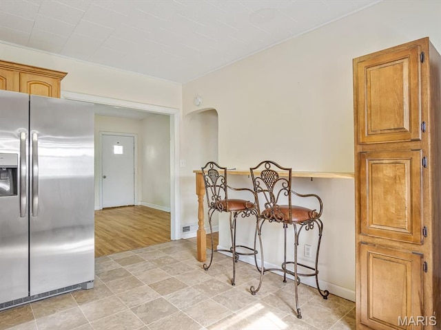 422 Washington St, Red Bud, IL 62278 - kitchen with stainless steel fridge, arched walkways, baseboards, and brown cabinets
