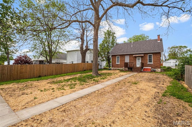 306 Walnut St, Waterloo, IL 62298 - view of front facade with a chimney, brick siding, and roof with shingles