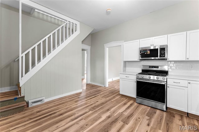 306 Walnut St, Waterloo, IL 62298 - kitchen featuring stainless steel appliances, baseboards, backsplash, and light wood-style flooring