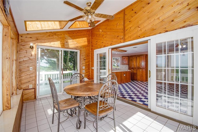 634 N 200th St, Vandalia, IL 62471 - dining area with healthy amount of natural light, wooden walls, ceiling fan, light tile patterned flooring, and a skylight