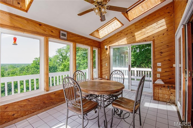 634 N 200th St, Vandalia, IL 62471 - dining area with light tile patterned flooring, a ceiling fan, a skylight, wooden walls, and vaulted ceiling